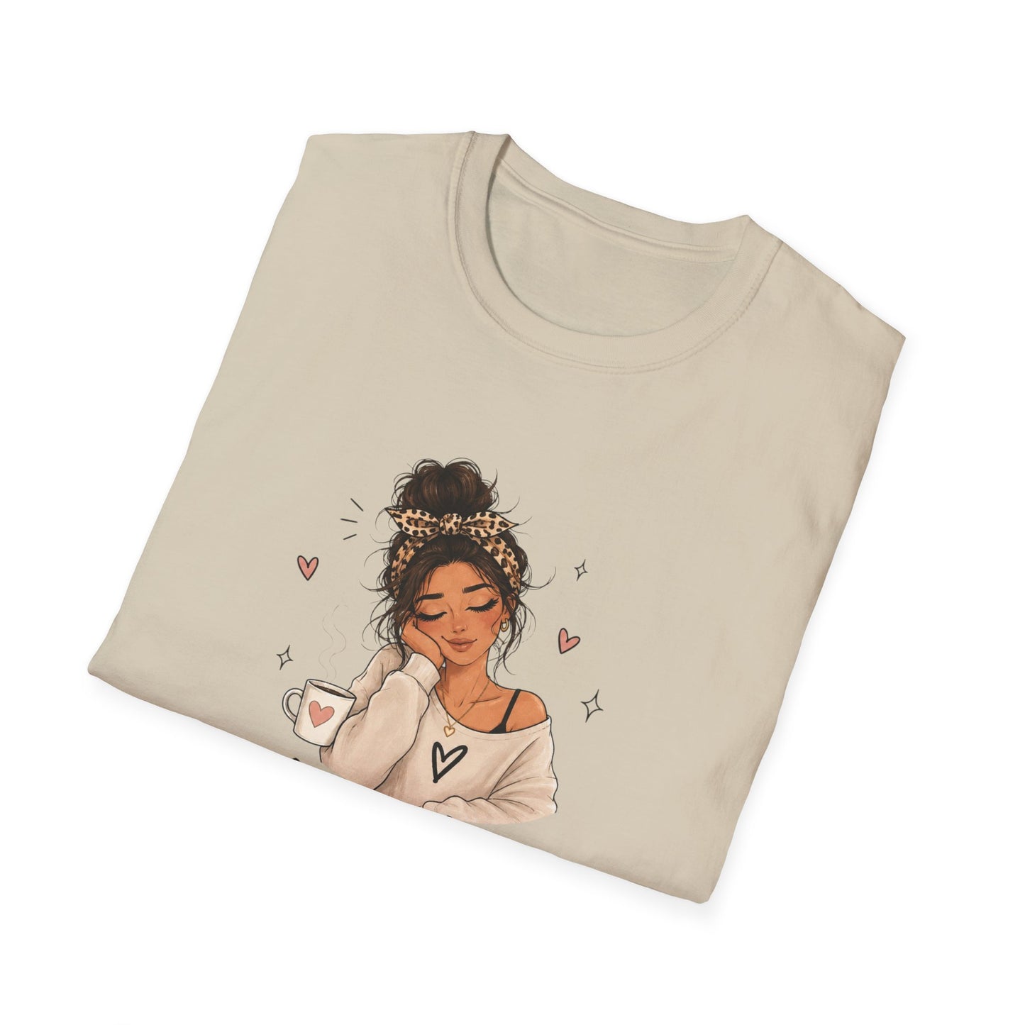 Folded beige t-shirt with a graphic of a woman holding a coffee cup on a white background