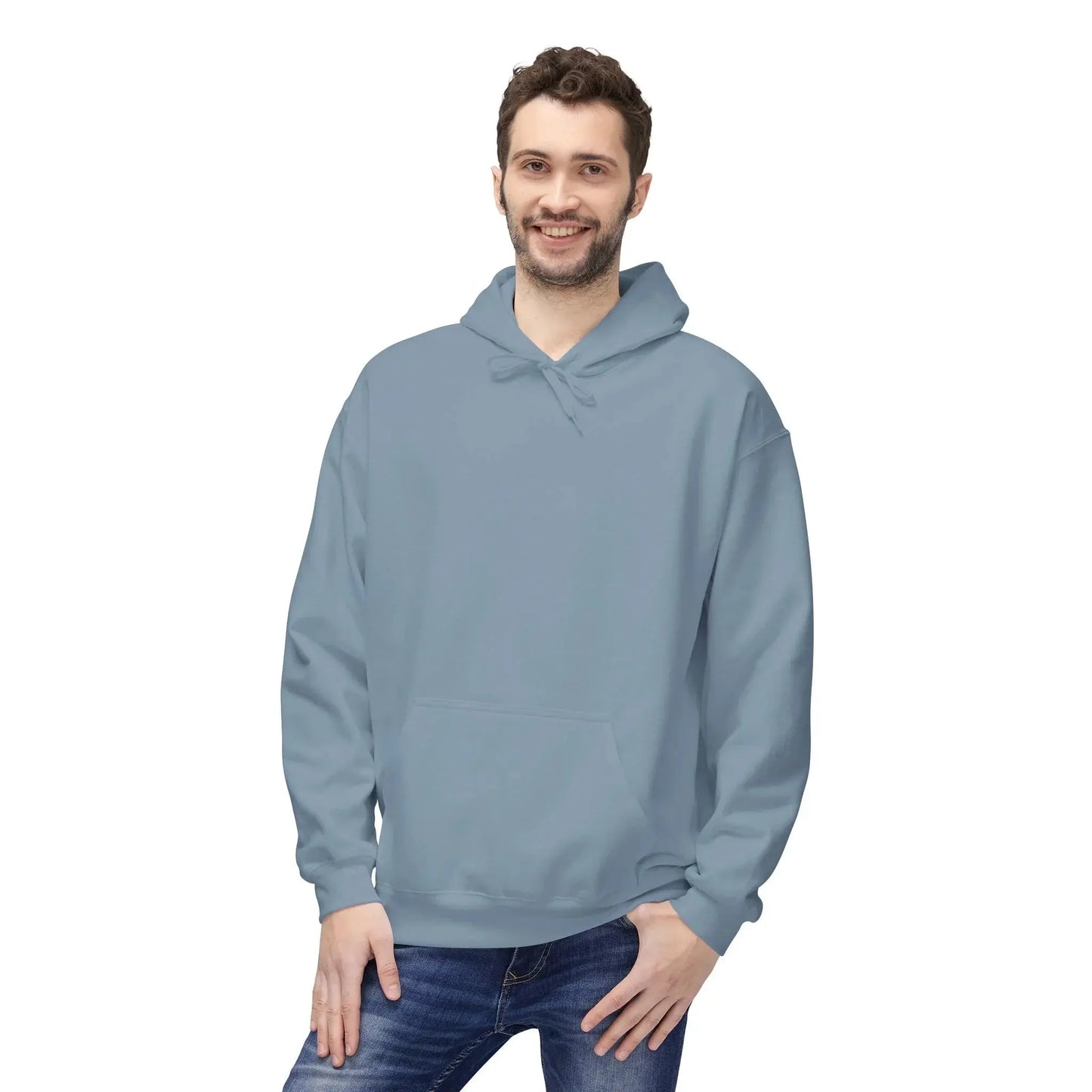 Smiling man wearing a plain light blue hoodie and blue jeans on white background